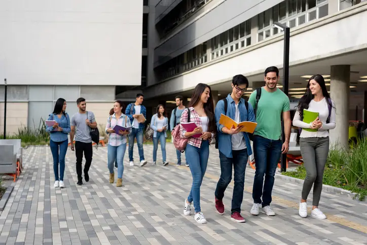 Young latin american students leaving the university campus after a day of class